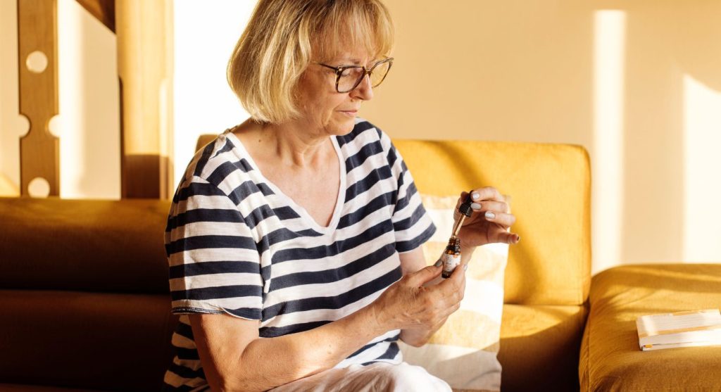 Woman using CBD oil for menopause symptoms
